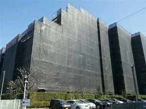 足場とメッシュシートで覆われた大規模修繕中の建物