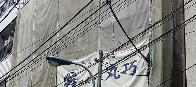株式会社丸巧の社名幕を掲げた工事現場